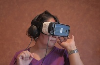 A woman wearing virtual reality goggles and headphones