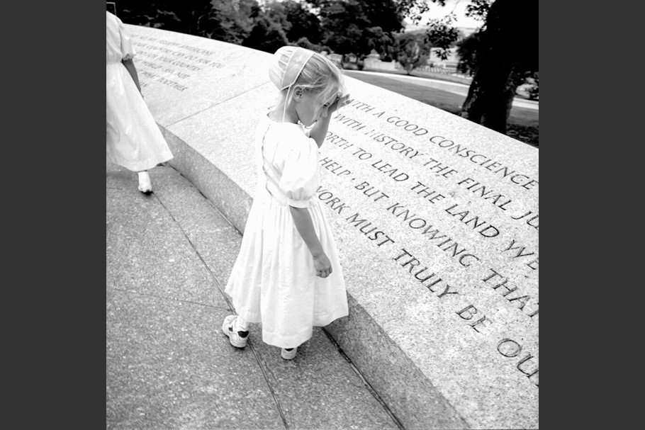A girl reading an inscription in stone.