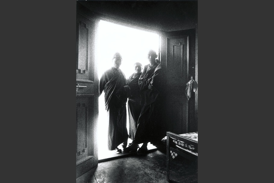Three monks standing in a doorway