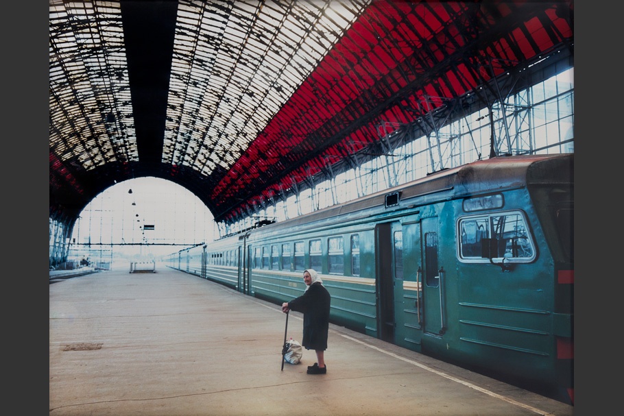 An elderly woman in a train station.