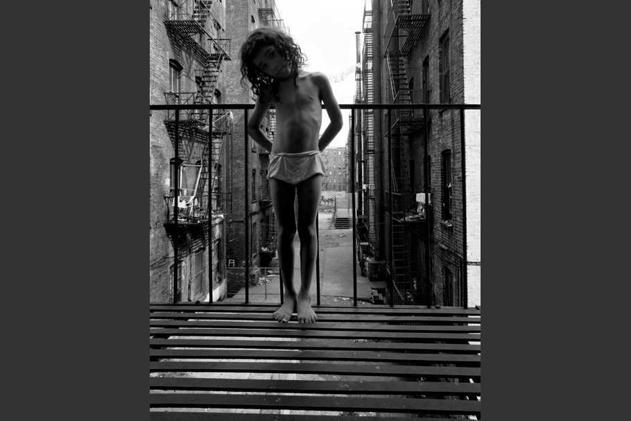 A child standing on a fire escape.