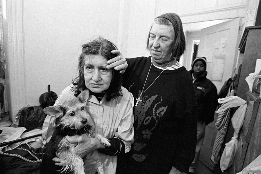 A nun comforting a woman with a dog.