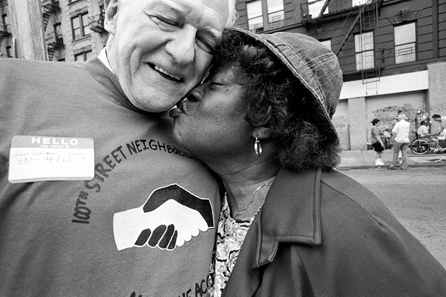 A woman kisses a man on the cheek.