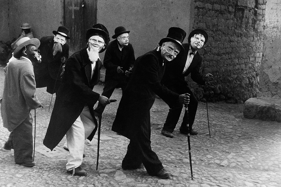 Men in masks and suits dancing.