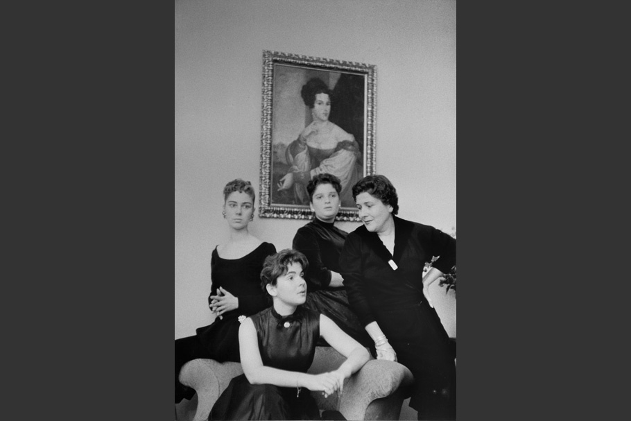 Women posing in front of a painting.