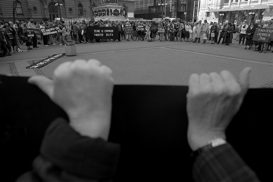 Hands holding a banner at a protest.