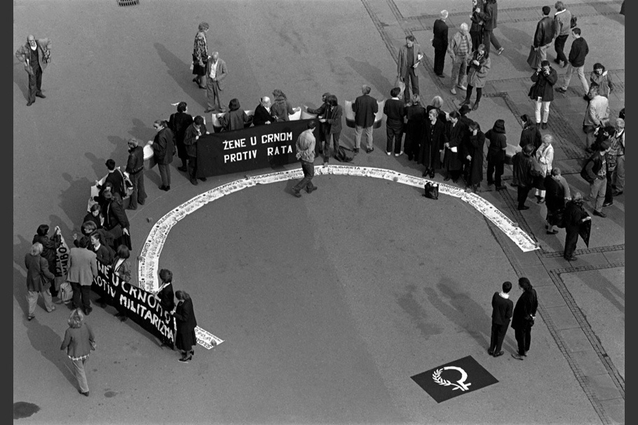 Protestors and signs in a semicircle. 