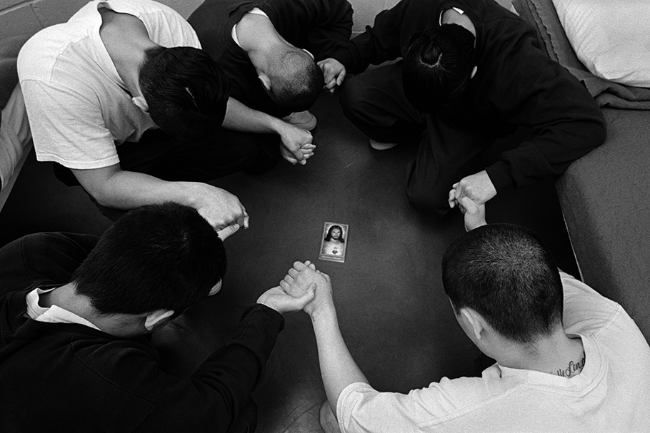 A group praying around an image of Jesus.