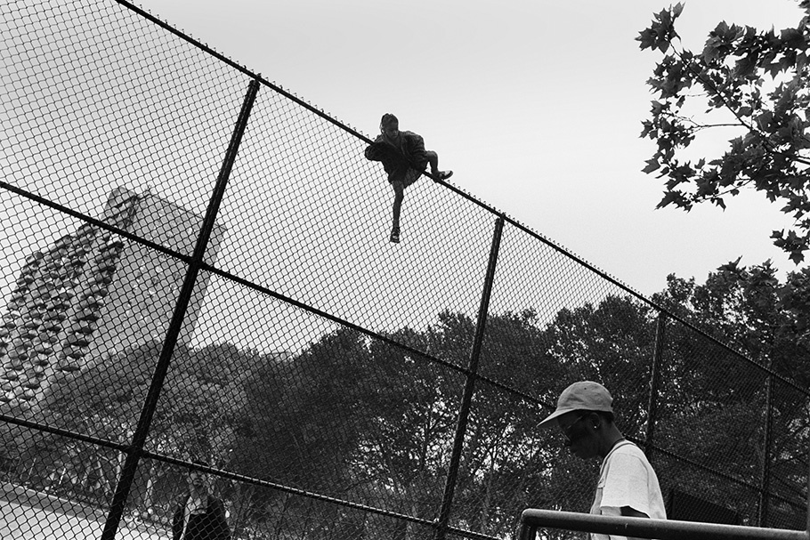 A boy climbing a fence.