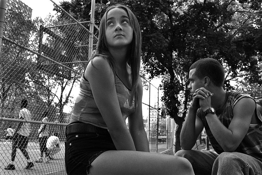A teenage boy and girl sitting outside.