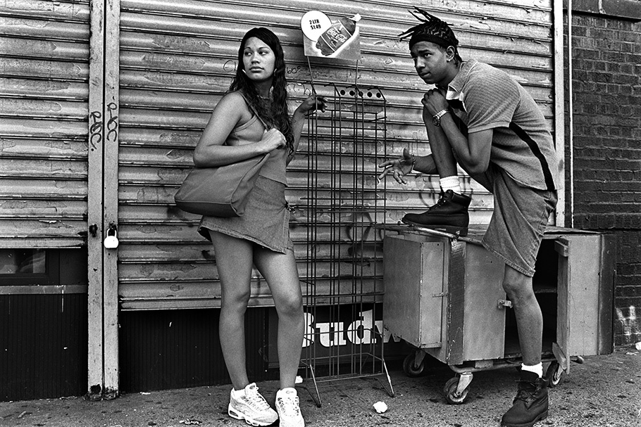 Teenage boy and girl in front of a closed store.