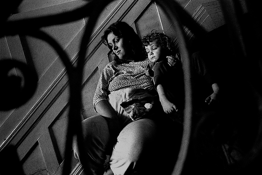 Mother and child viewed through a staircase railing.