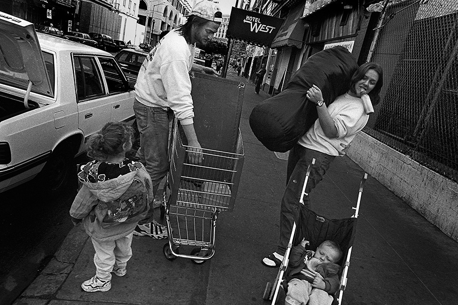 A family moves belongings with a shopping cart.