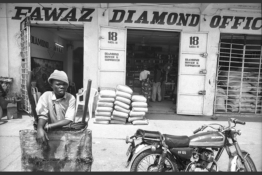 A person and a motorcycle in front of a diamond shop.