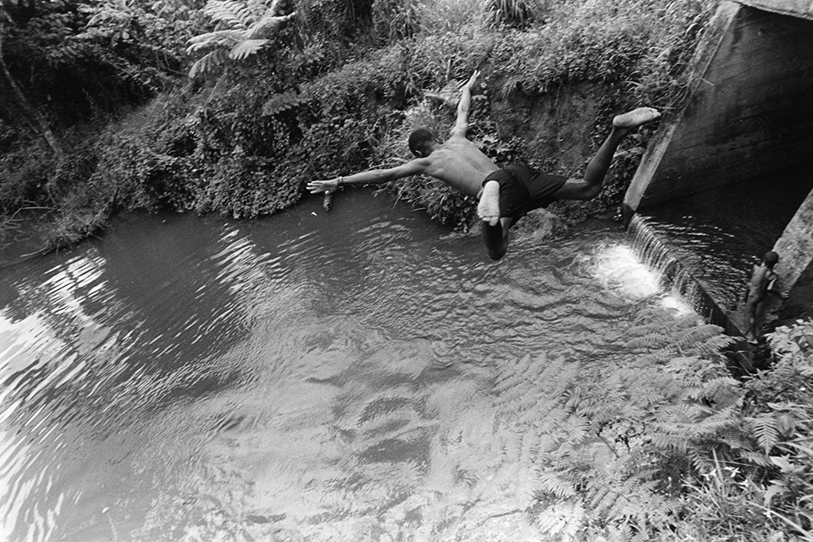 A boy jumping into a swimming hole.
