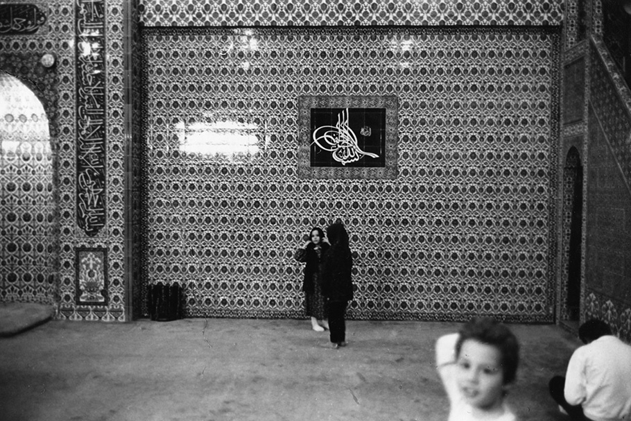Children in front of a patterned wall. 