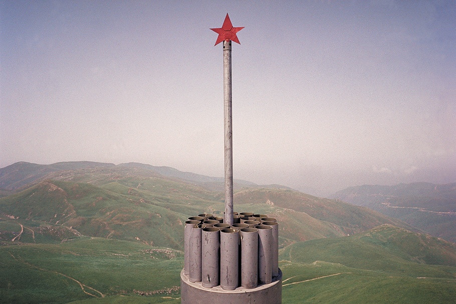 Memorial with a star in front of a landscape.