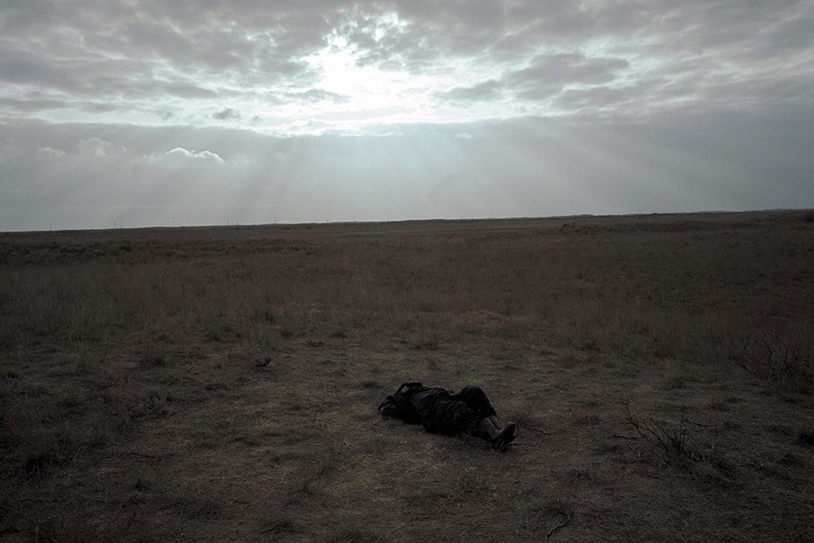 A person laying in a field.