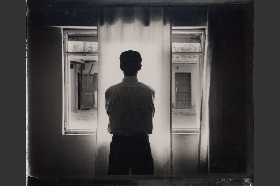 A man silhouetted in front of a window. 