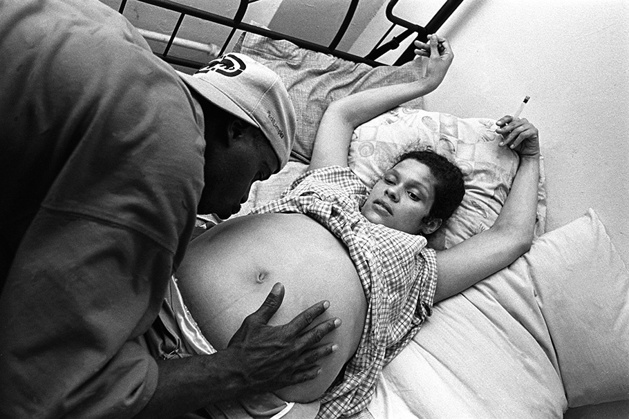 A man kisses the stomach of a pregnant woman.