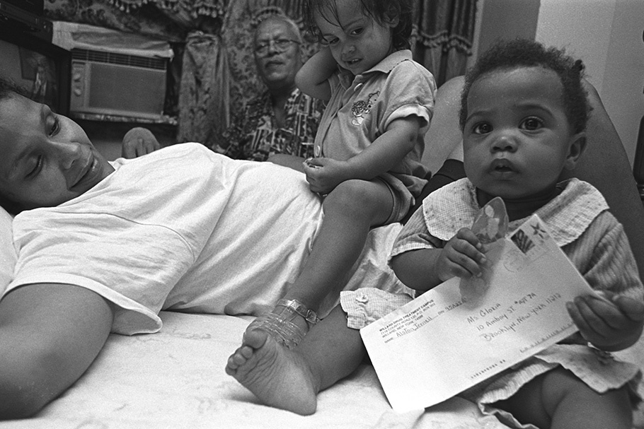 A woman with two children, one holding a letter.