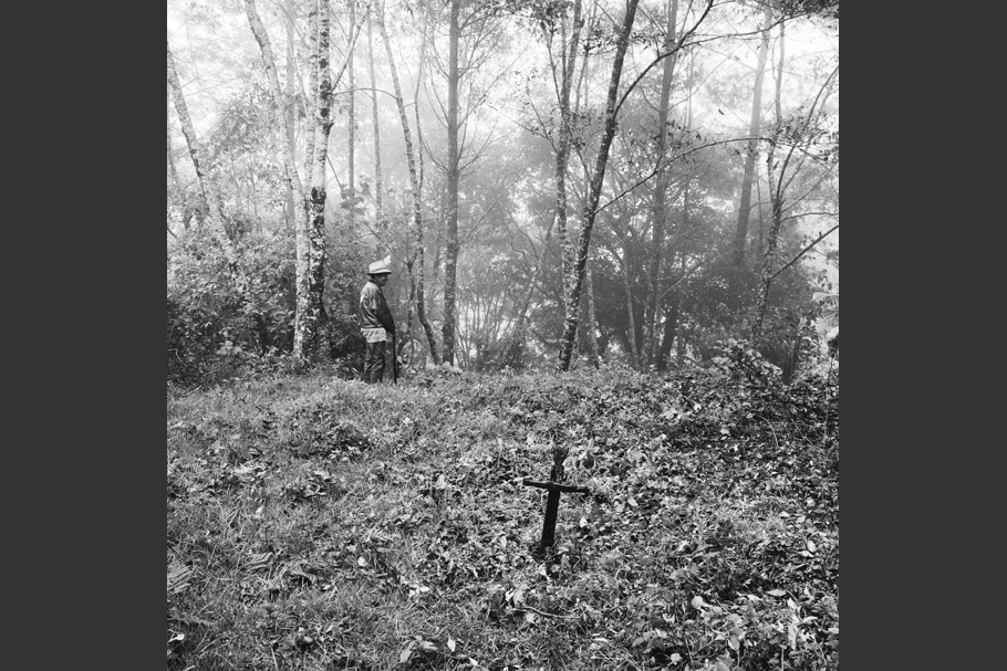 A wooded landscape with a cross and a man.