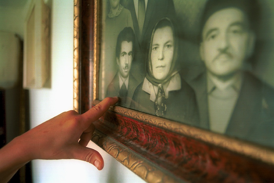 A hand pointing to a framed photograph.