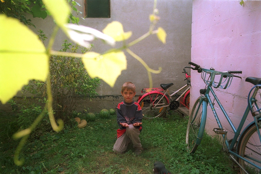 A boy with bicycles and a purple wall.