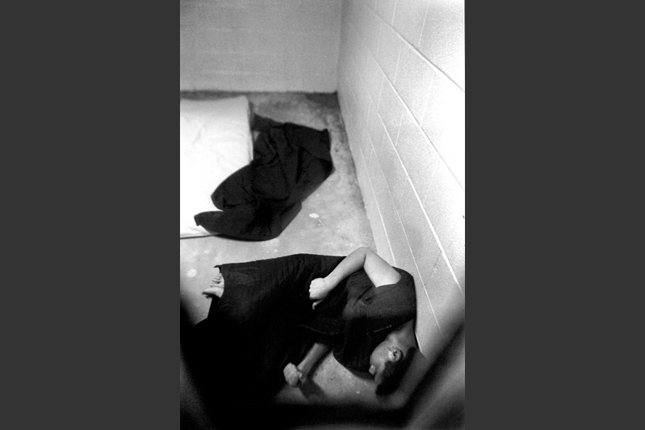 A boy passed out on the floor of a cell.