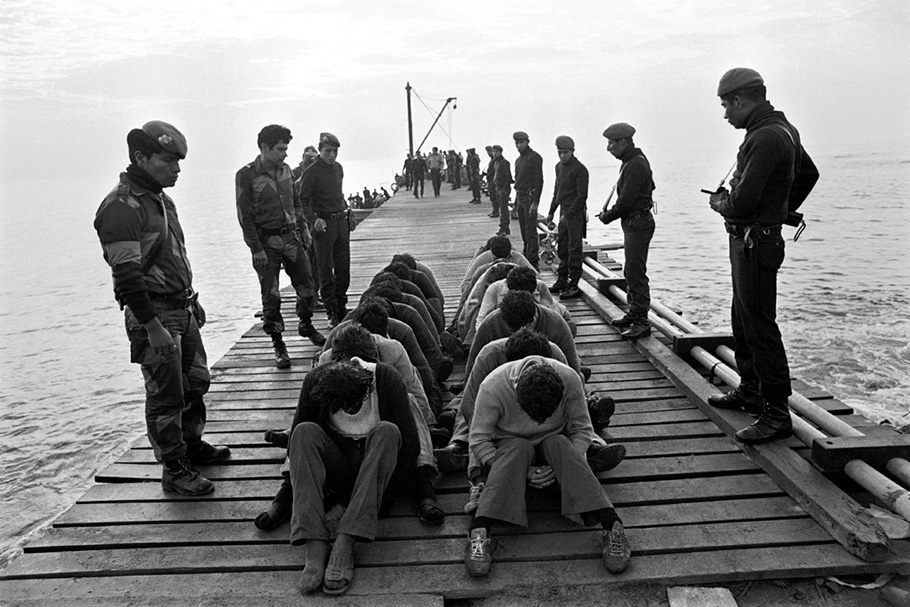 Soldiers and prisoners on a dock. 