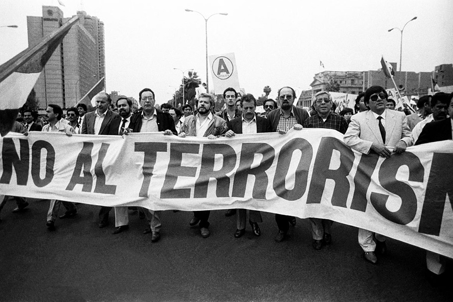 Demonstrators marching with a large sign.