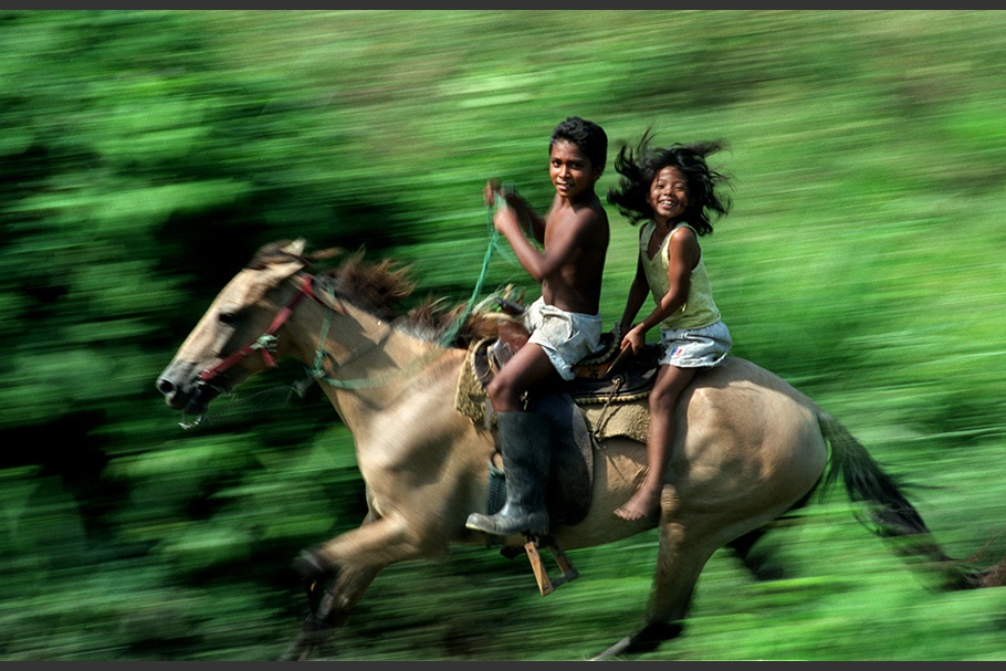 Two children riding a horse.