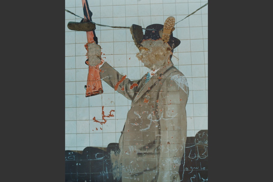 Defaced mural of Sadam Hussein.