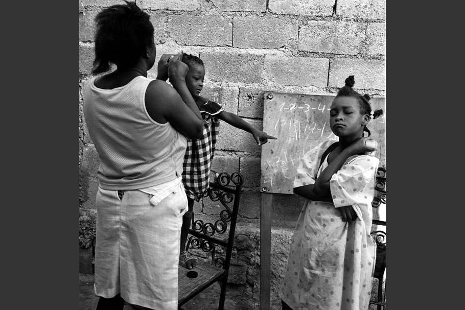 A women fixing a child’s hair.