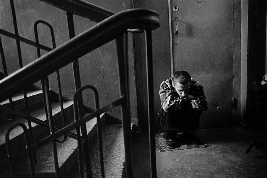 A man crouched in a stairwell.