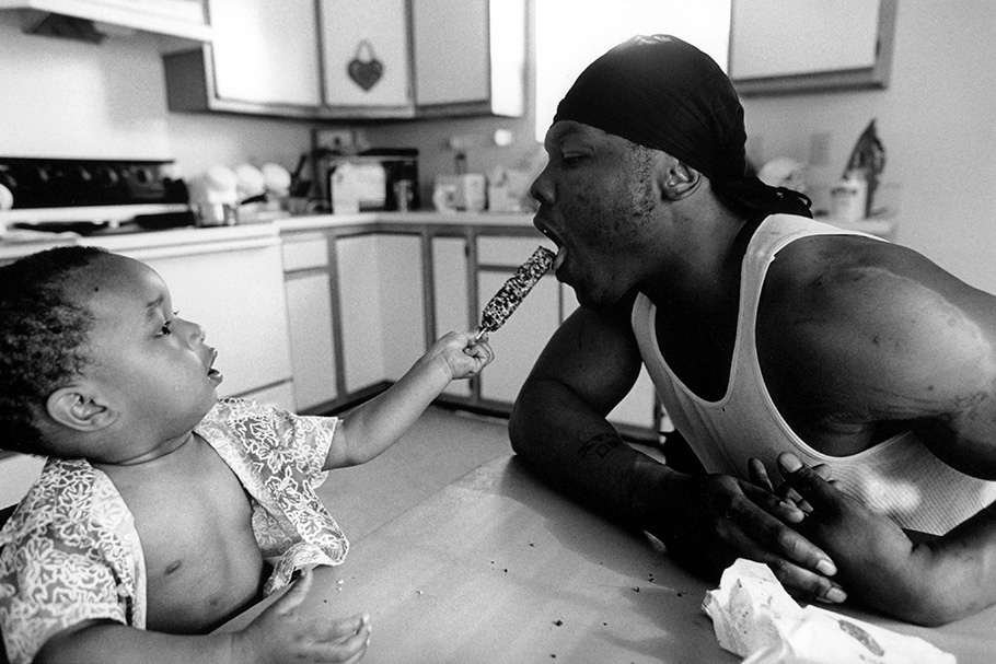 An infant feeding his father a popsicle.