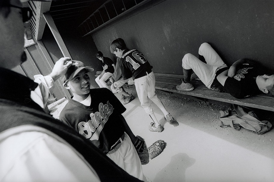 Little league baseball players in a dugout.