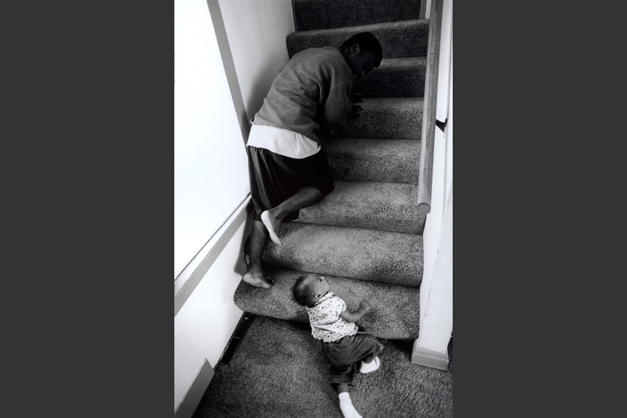 A father and infant climb up stairs.