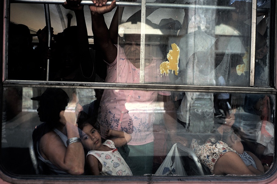 People viewed through a bus window.