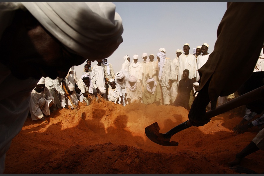 A group of people digging a grave.