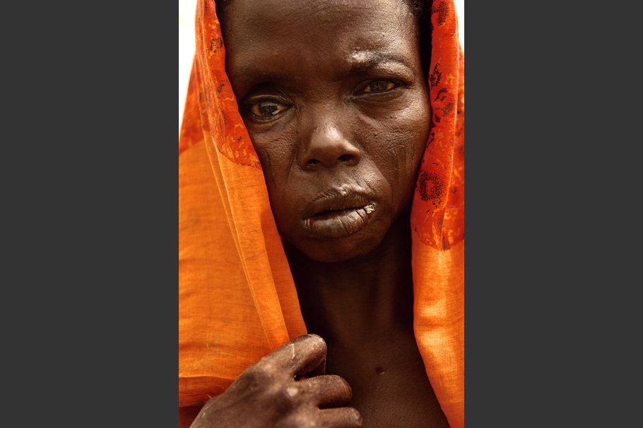 Woman with orange cloth covering her head.