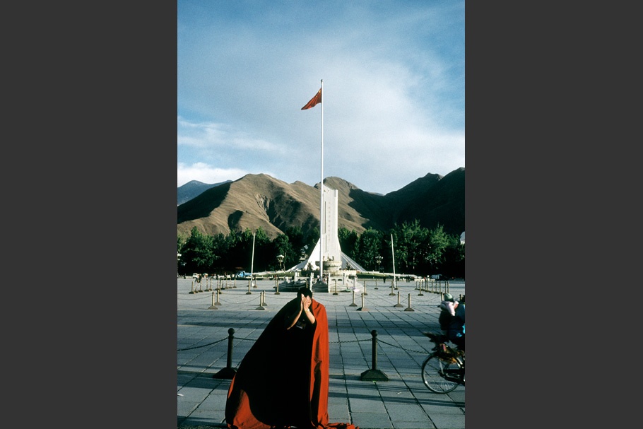 A monk in front of a flag.