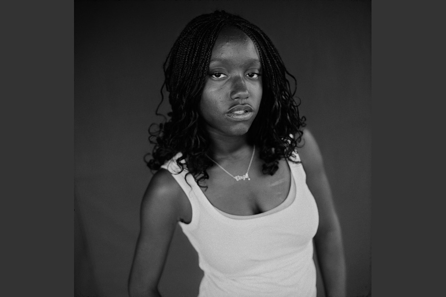 Black and white portrait of a girl in a white tank top.