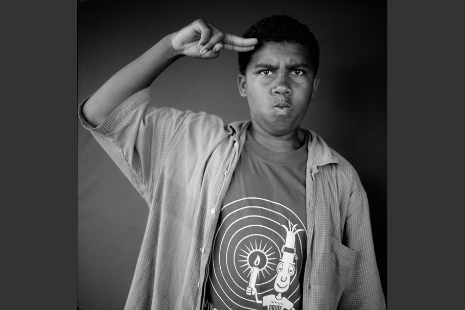 Black and white portrait of a boy saluting.