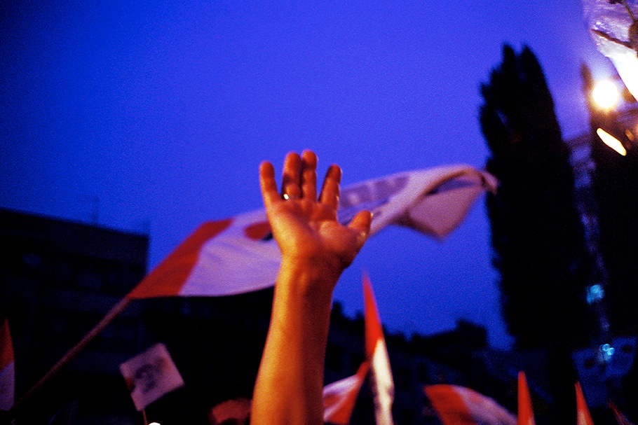 Hands and a flag against a night sky.
