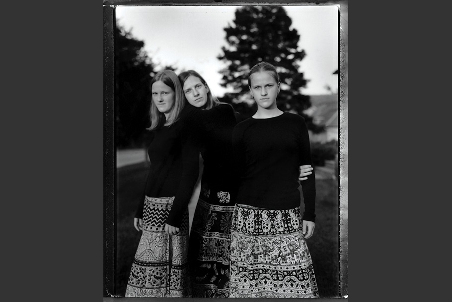 Three sisters in long patterned skirts.