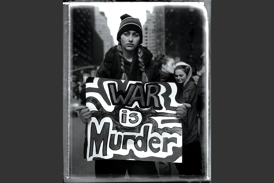 Teenage girl carrying a “War is murder” sign at antiwar protest.