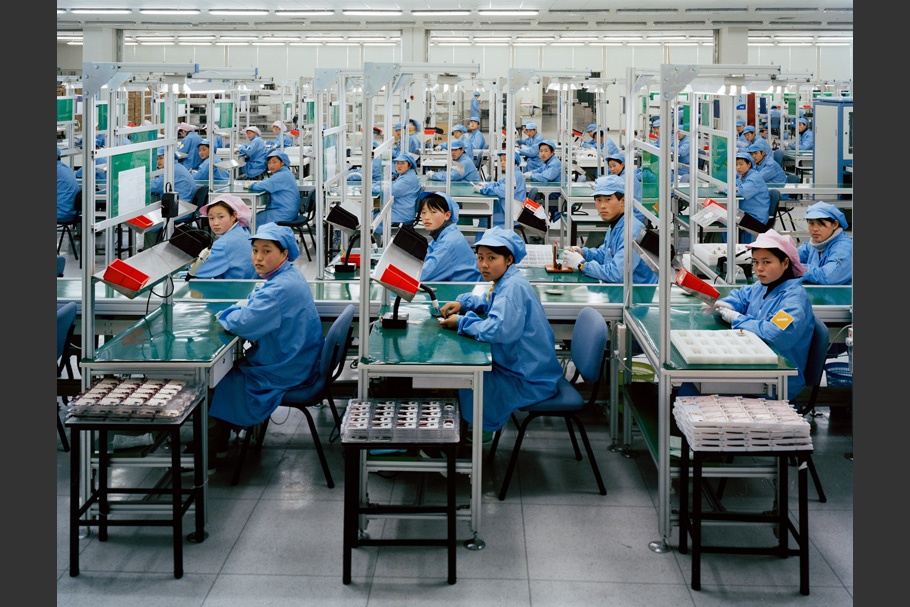 Factory workers in blue uniforms.