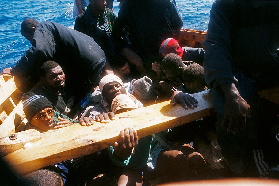 Men on a boat facing camera.