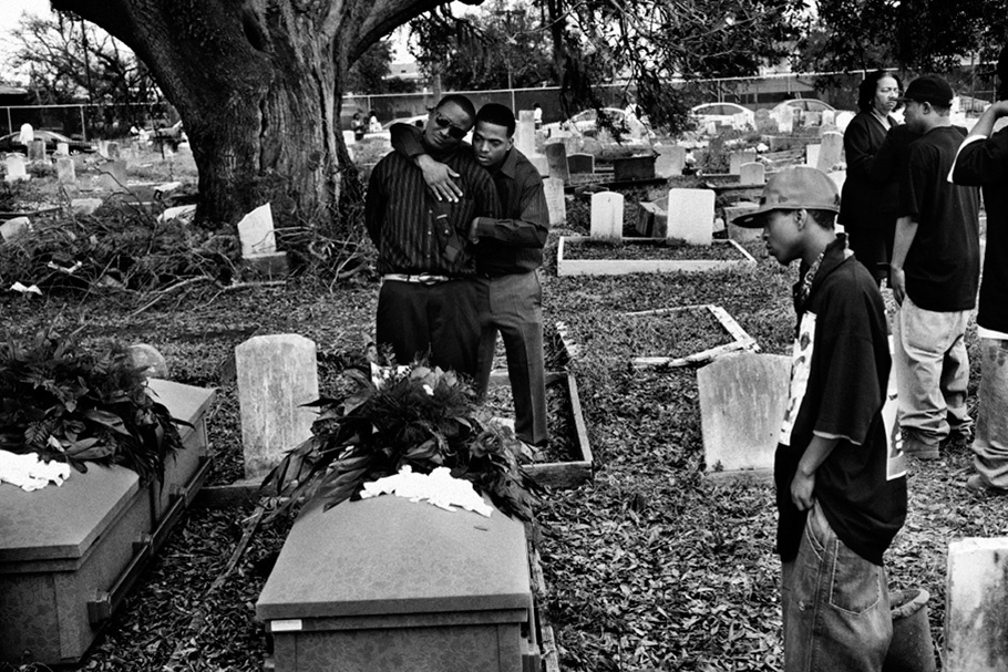 Men embracing in cemetery.